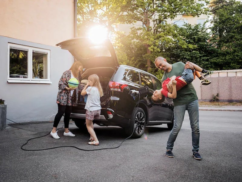 family playing near car